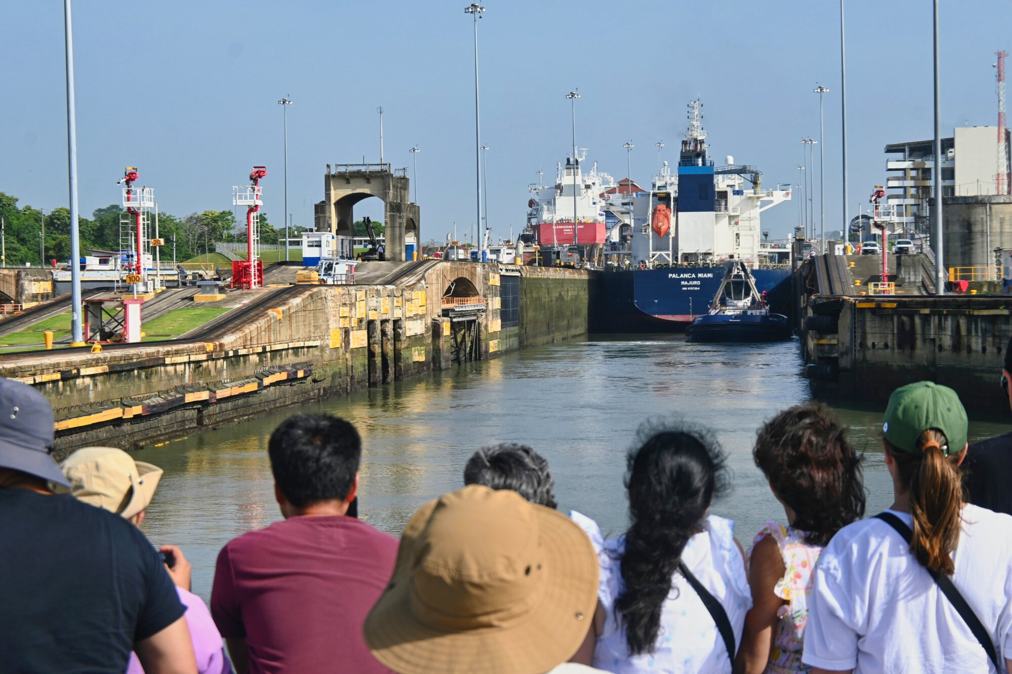 Travelers watching a large ship pass through the Panama Canal locks during a partial canal transit.