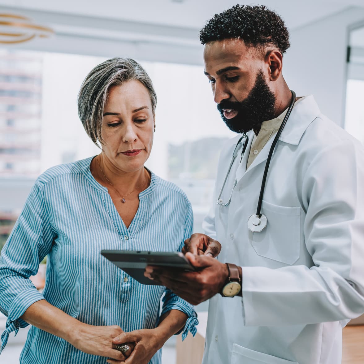 Doctor using a computer and writing down information