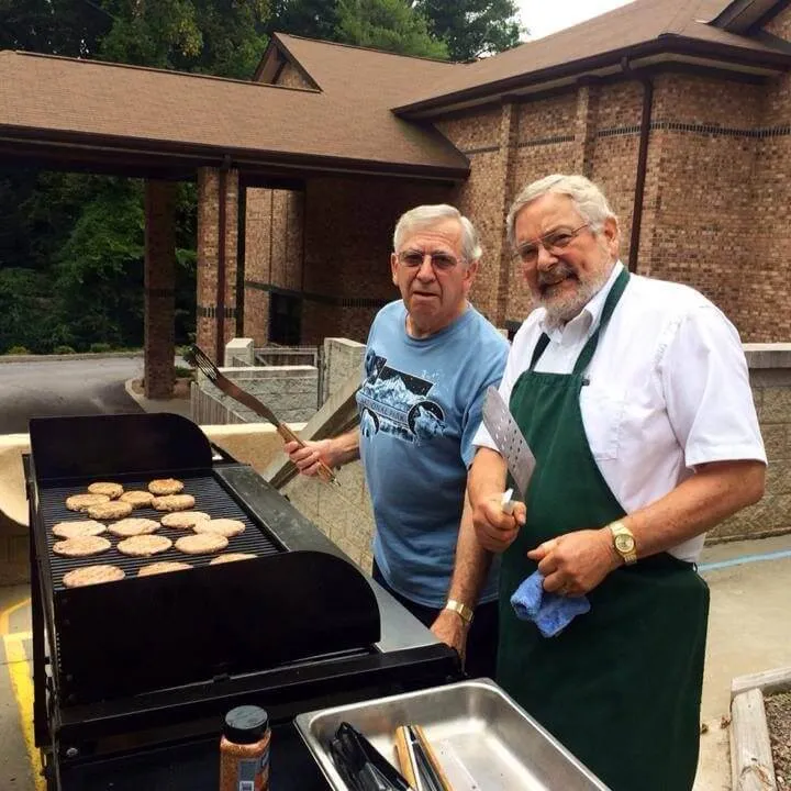 Two people grilling burgers at Grace Lutheran  Church