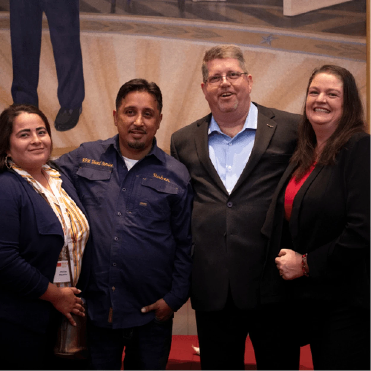 A grayscale photograph of four people standing together, likely representing the organization's team or founders.