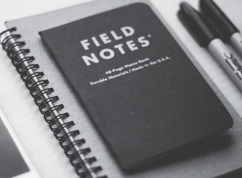 A notebook with the title field notes written on it