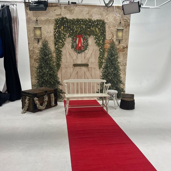 A ready-built barn-door holiday set with a wreath, bench and red runner