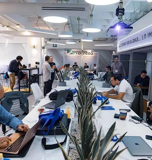 Man in business attire walking across a street with bold diagonal zebra crossing stripes and long shadows.