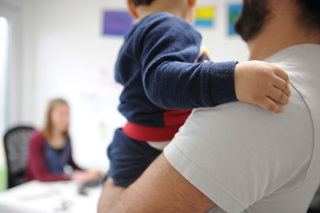 Geflüchteter Familienvater hat sein Kind auf dem Arm