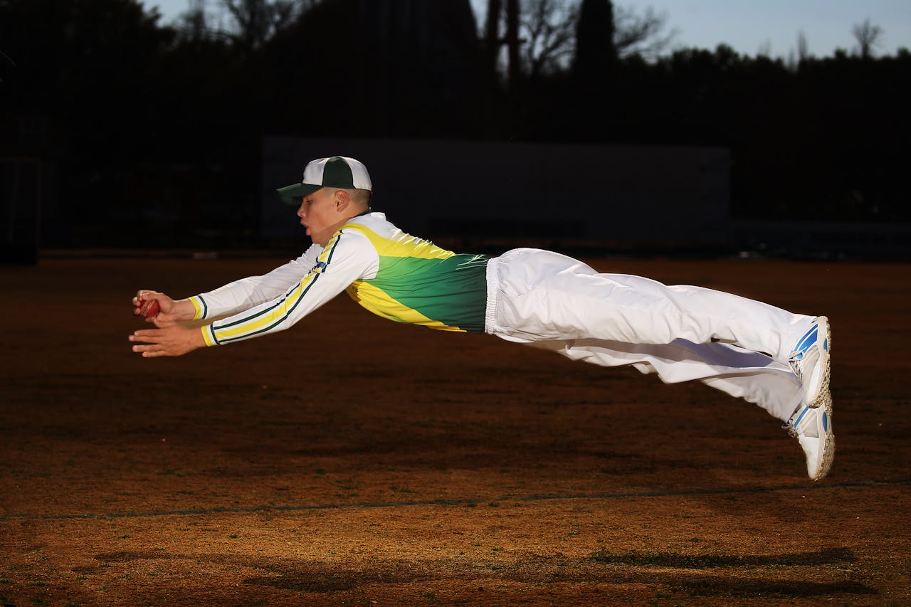 a fielder diving mid-air to catch a ball