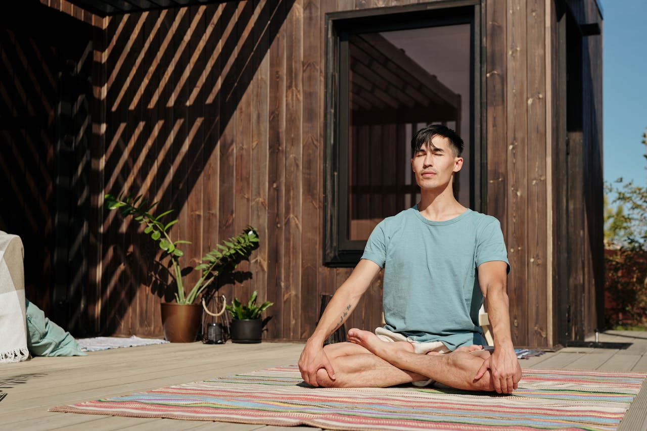 a man meditating in the balcony of his house