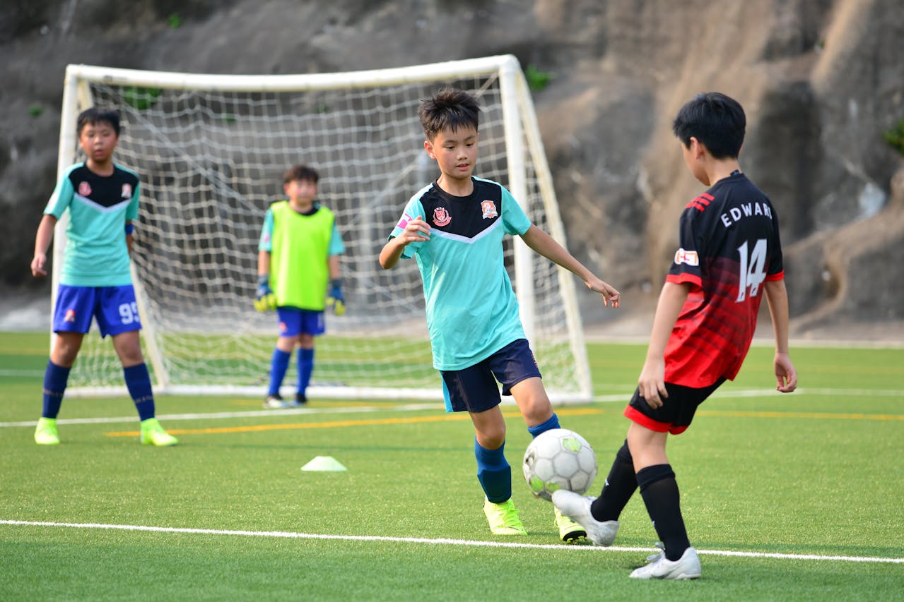 a group of young boys playing a football game on a field