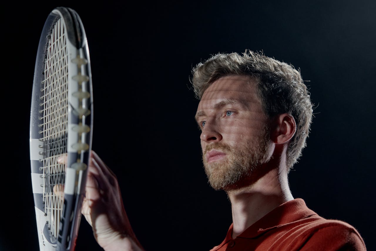 a tensed tennis player looking at his racket