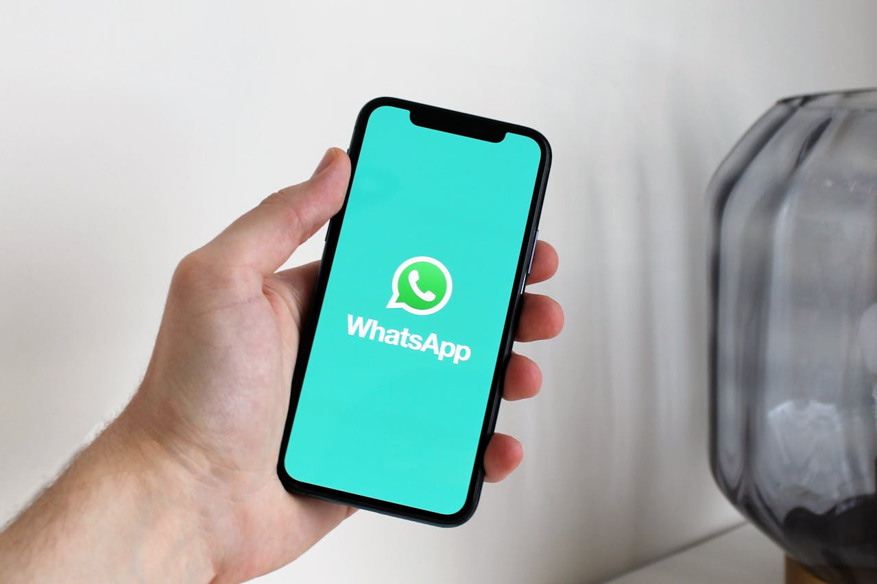 a phone display with the WhatsApp logo
