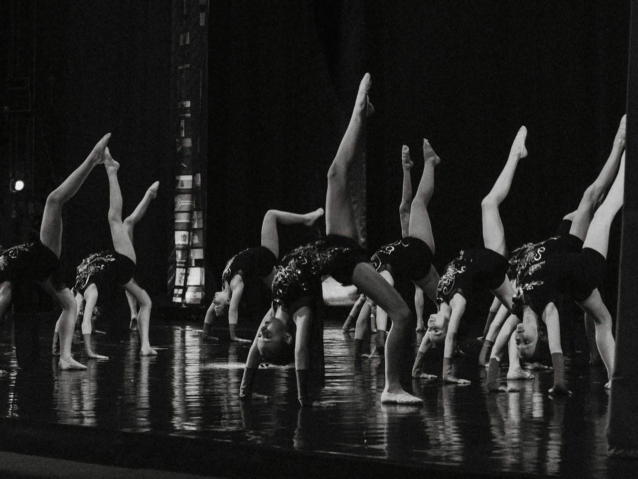 a group of young girls in costume performing on stage at a dance recital