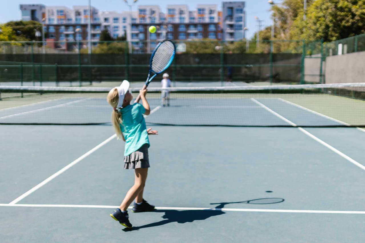 two young kids playing a tennis match