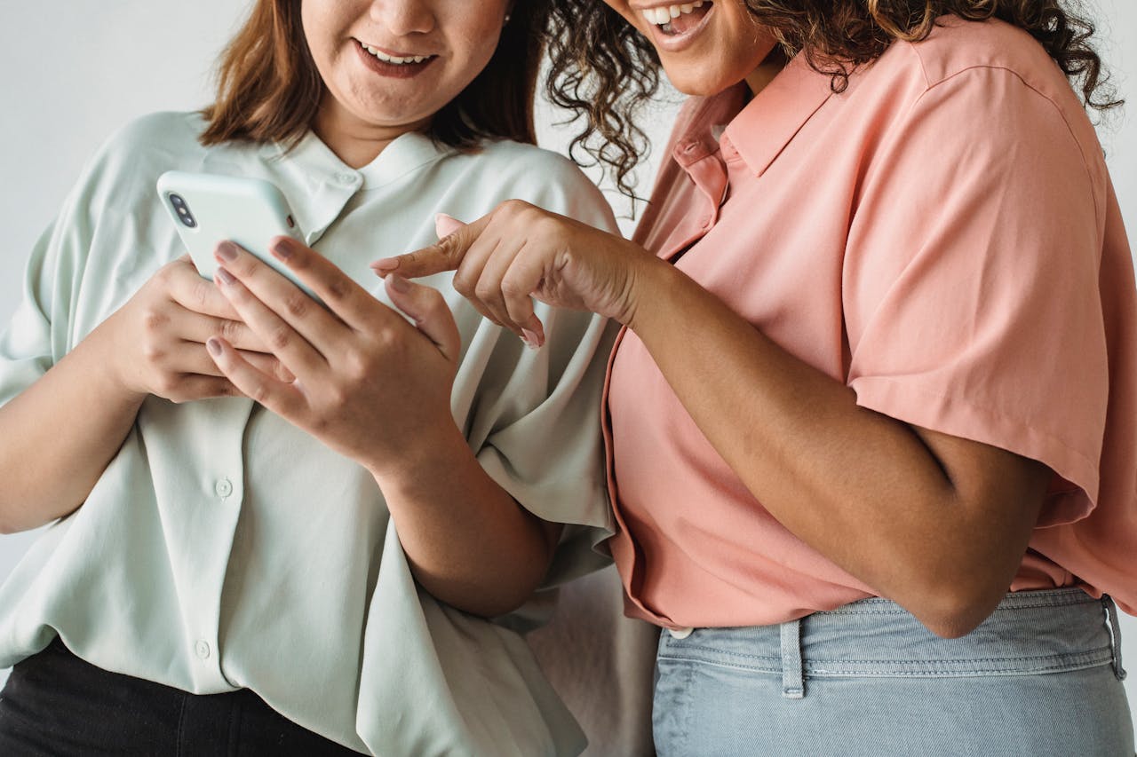 two women looking into a phone screen and smiling