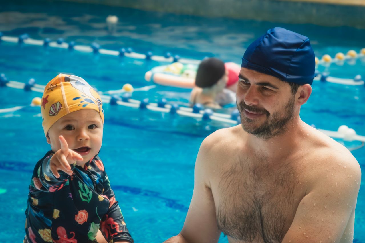 a swim coach in the pool with a toddler learning how to swim