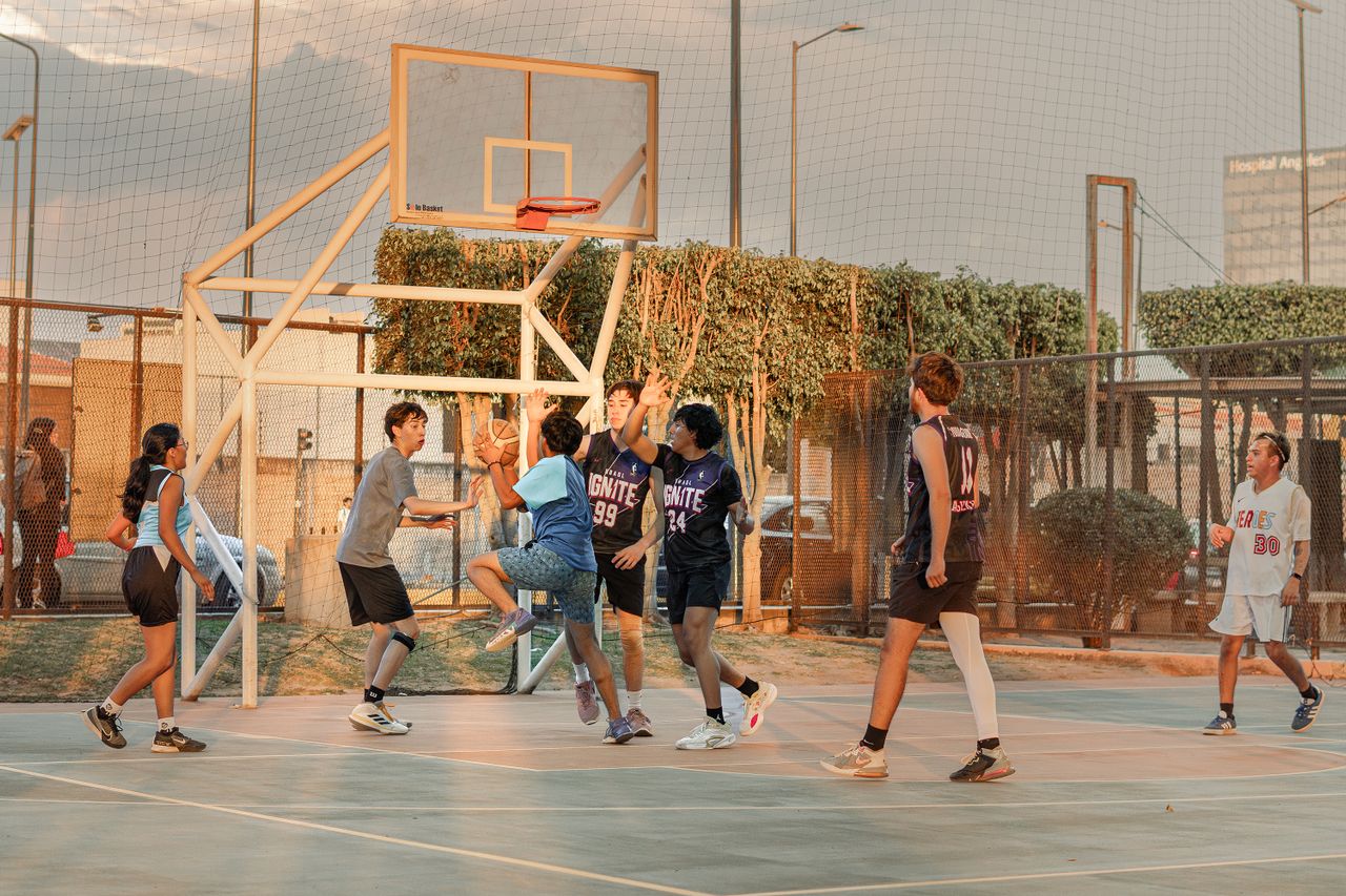 A bunch of teenagers playing basketball