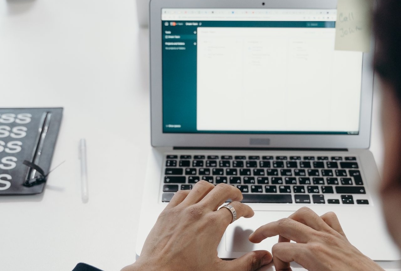 Person typing on a laptop in a modern office setting.