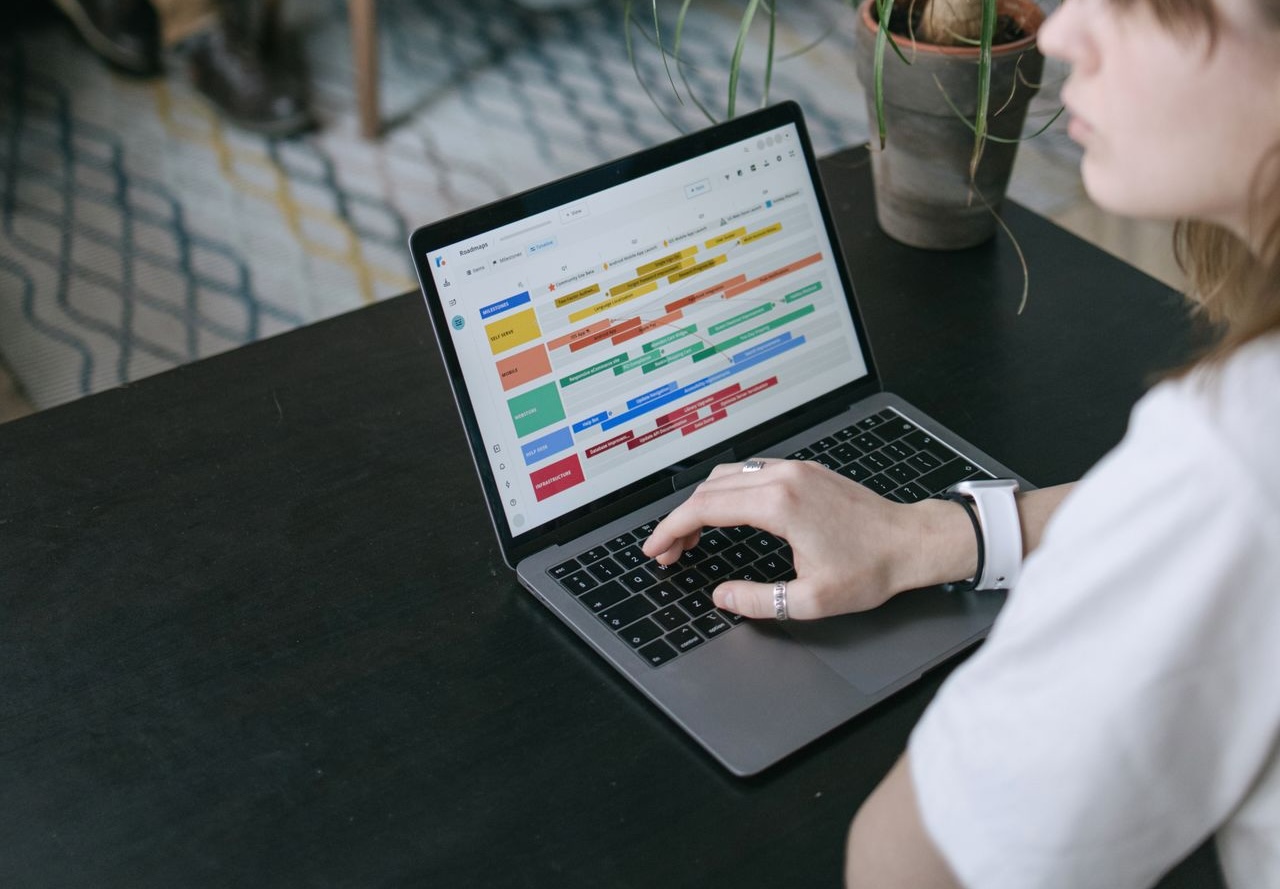 A woman looking at an online olour-coded schedule on her laptop