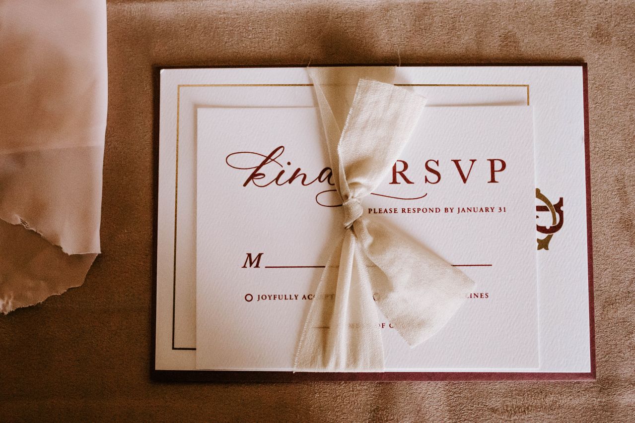 An elegant RSVP invitation card with a tied bow