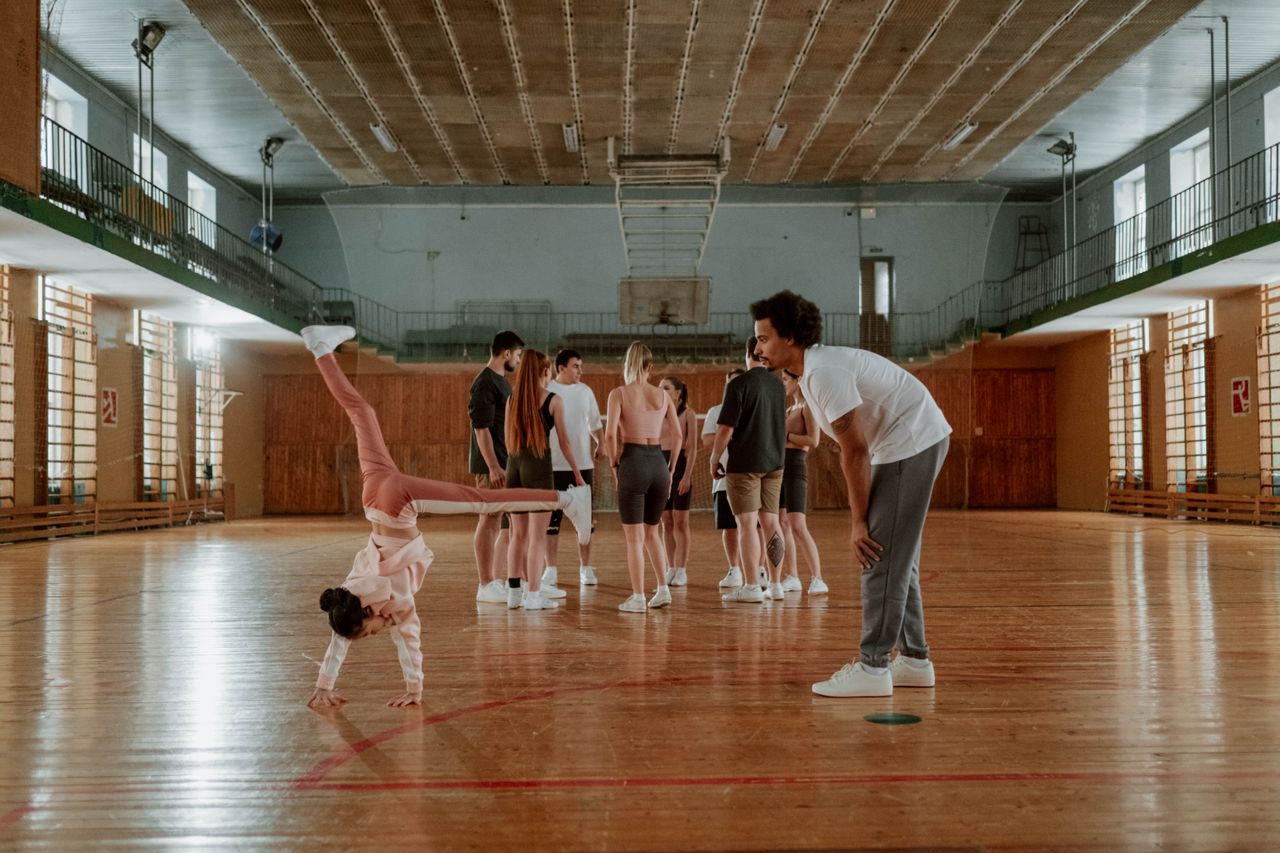 Gymnastics coach instructing a student of the academy