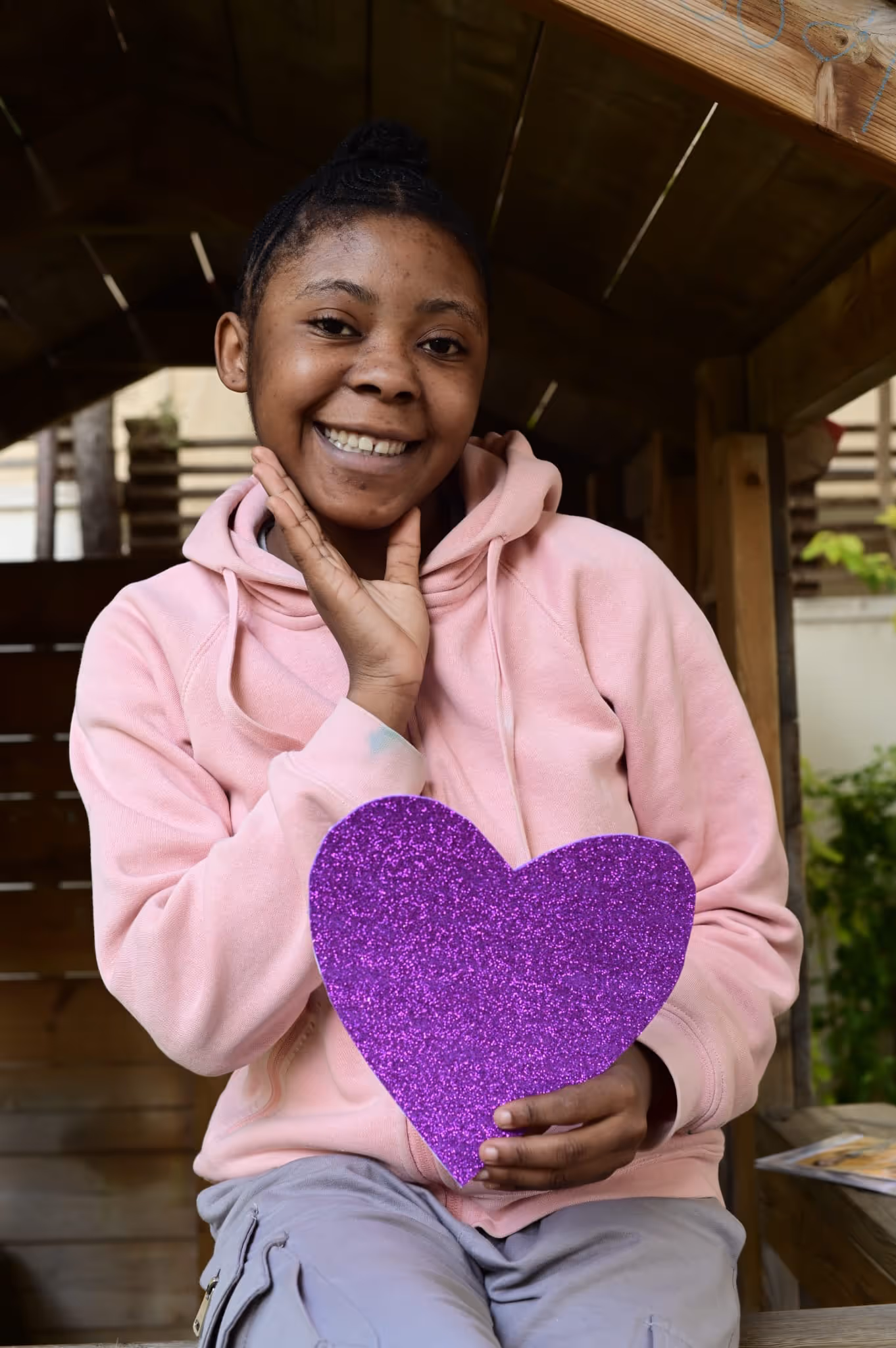 A woman sitting on a bench holding a purple heart.