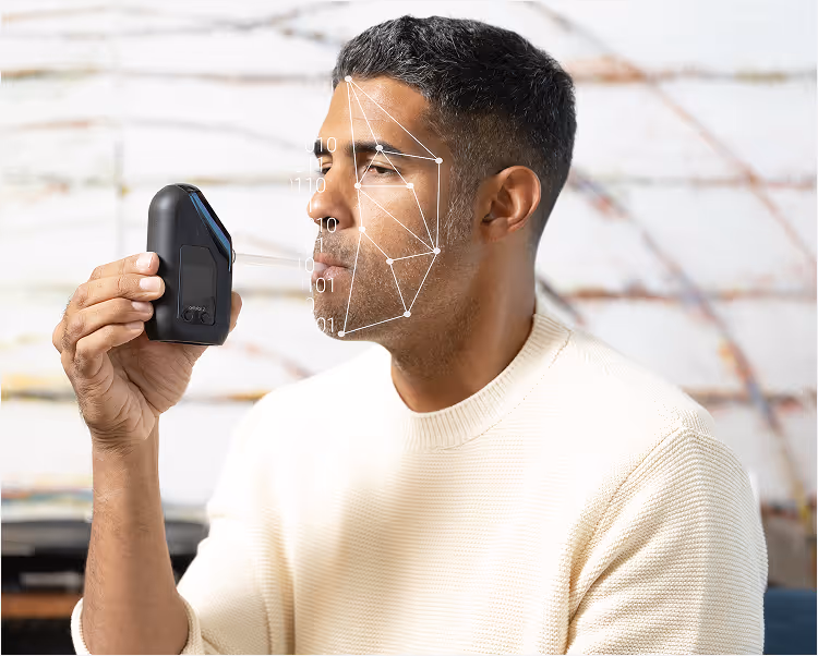 A man blowing into a Soberlink device
