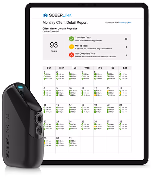 Tablet displaying a Soberlink Monthly Client Detail Report for Jordan Reynolds with compliant, missed, and non-compliant test counts, alongside a black Soberlink 7.0 device.
