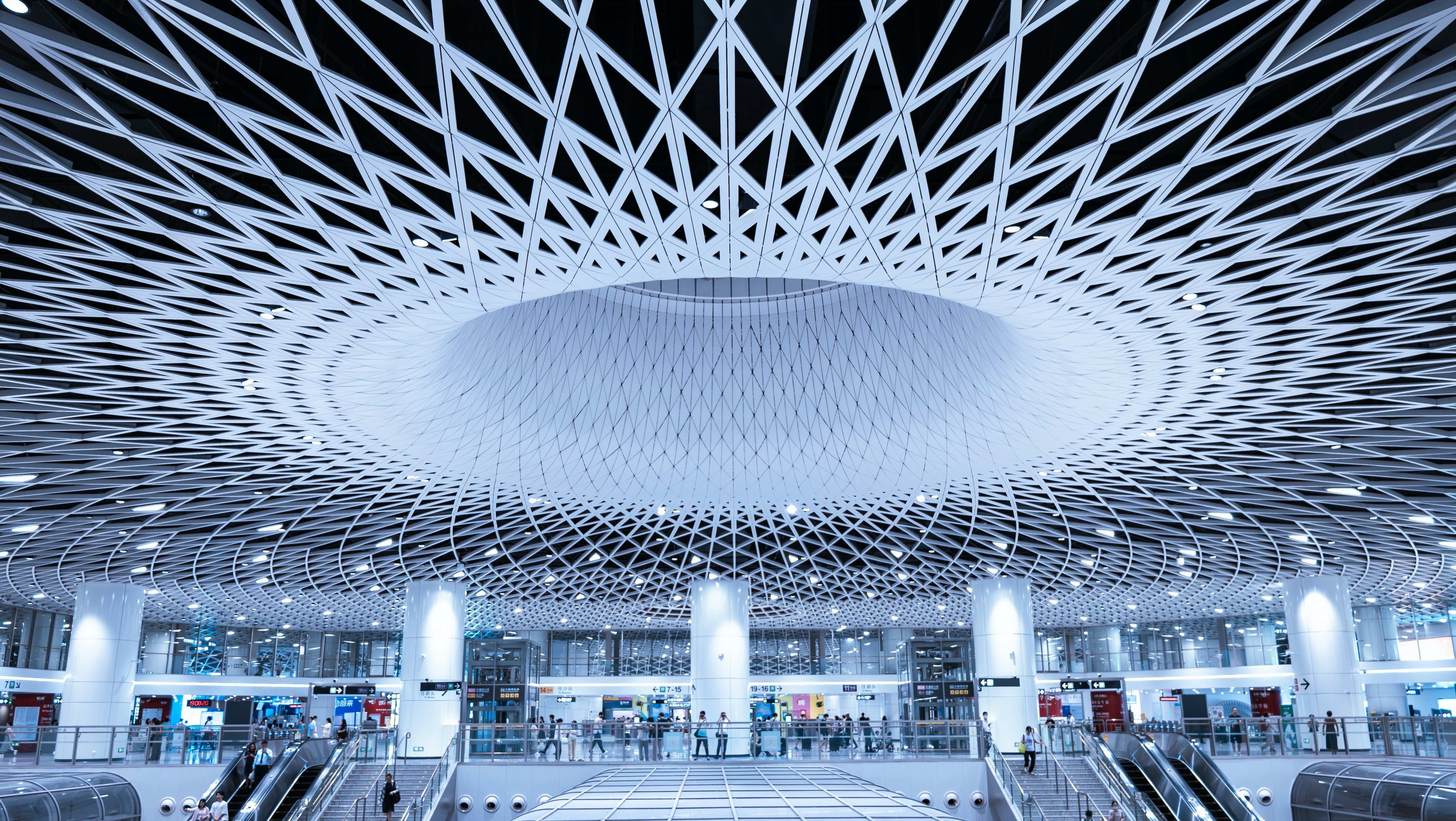A professional woman is sitting in a seat on an airplane while working on her laptop.