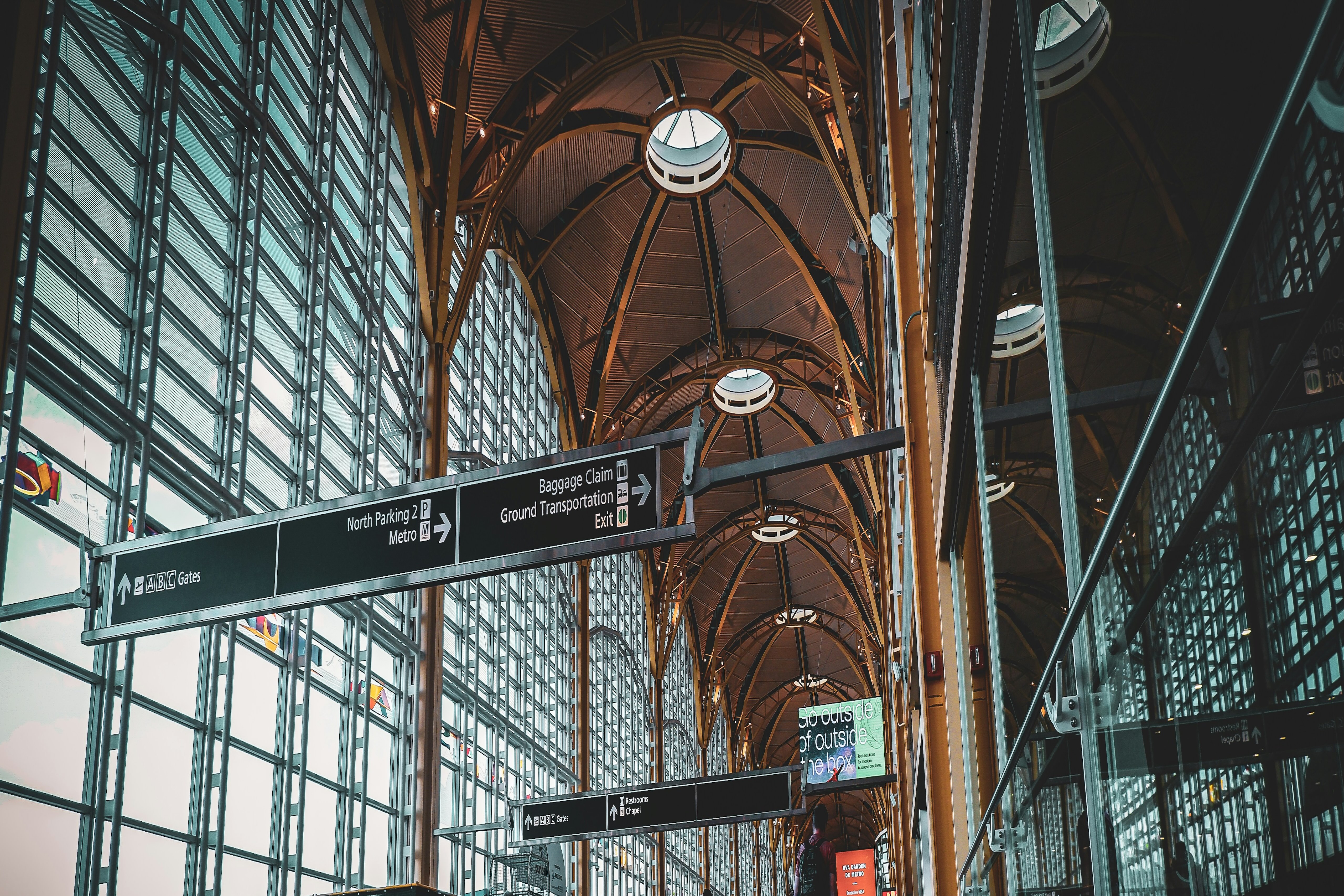 A professional woman is sitting in a seat on an airplane while working on her laptop.