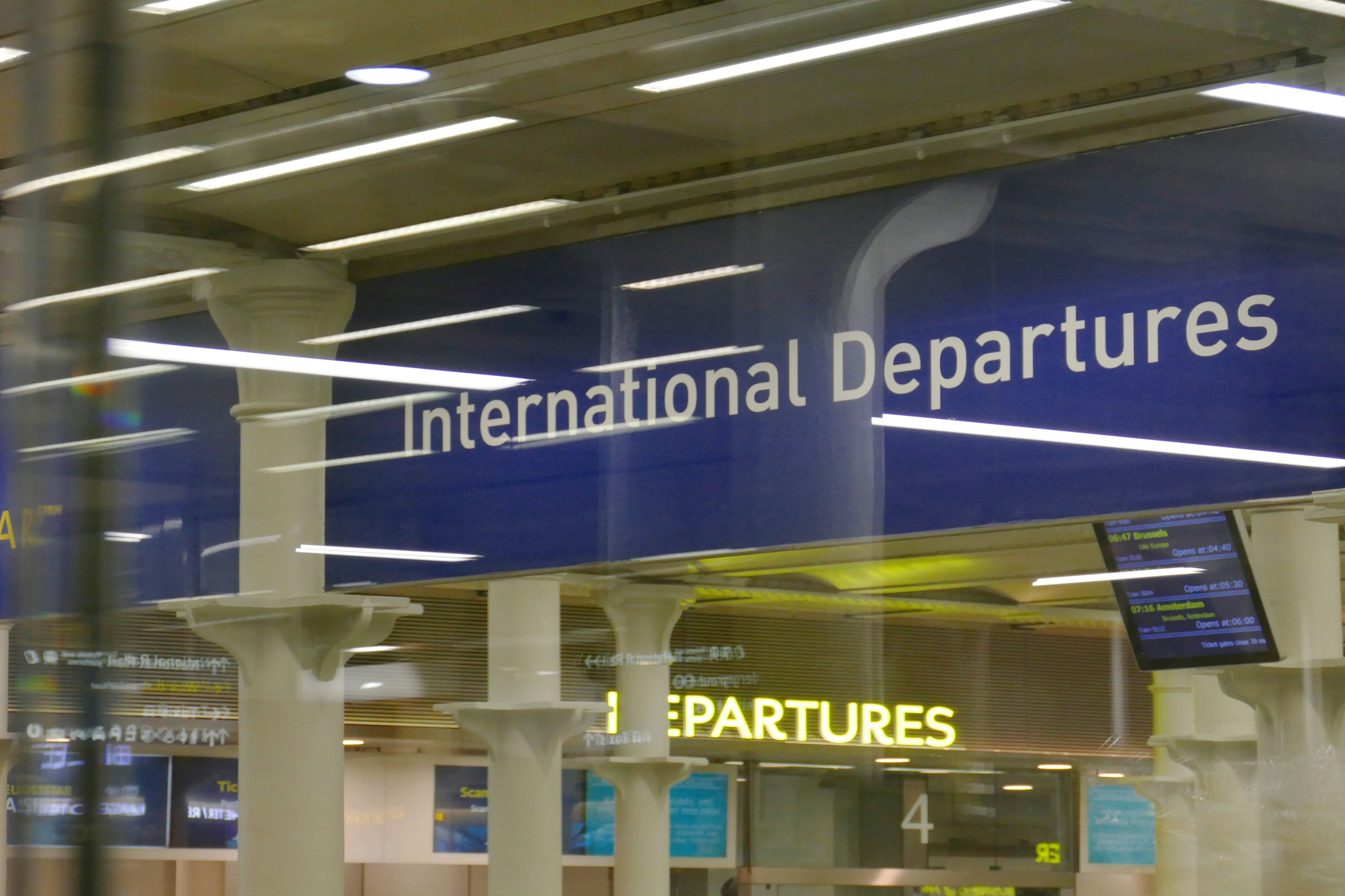A professional woman is sitting in a seat on an airplane while working on her laptop.