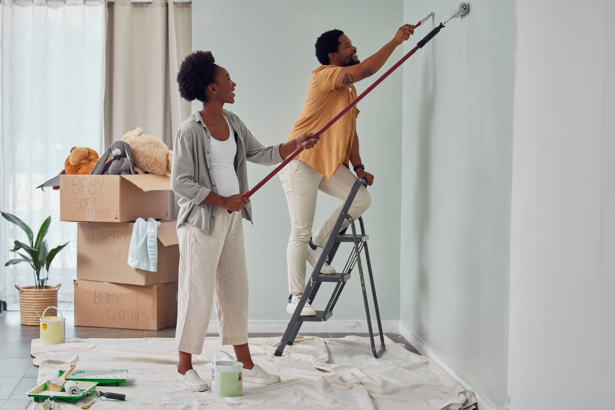 Couple in house painting white walls
