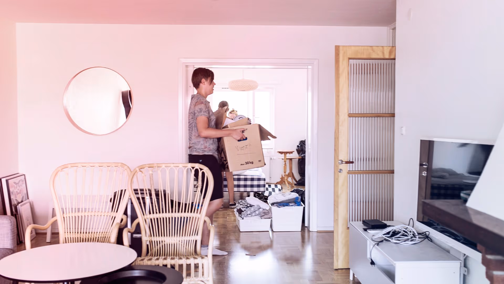 Jongen draagt een verhuisdoos door het huis