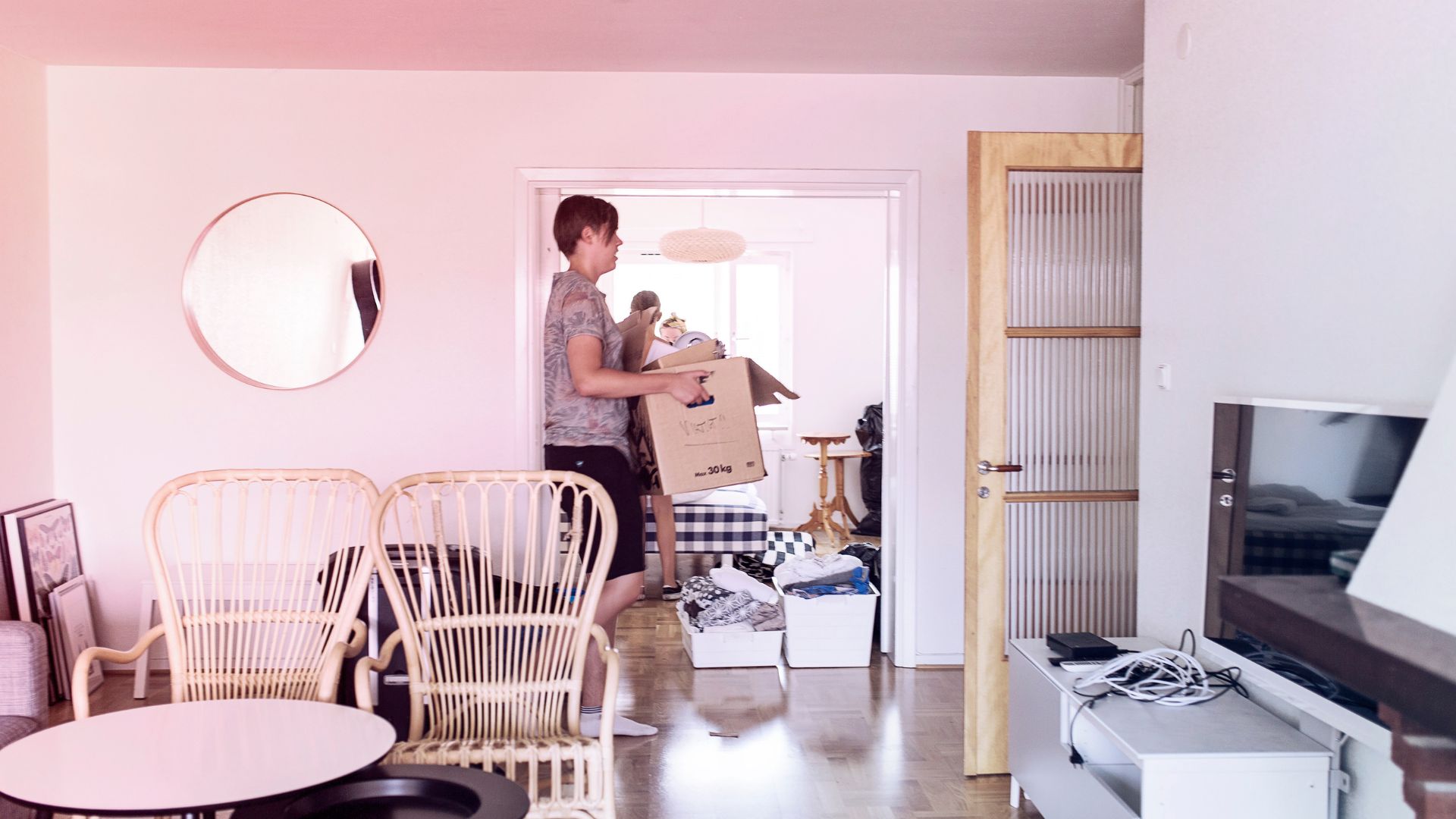 Man met een verhuisdoos in de woonkamer