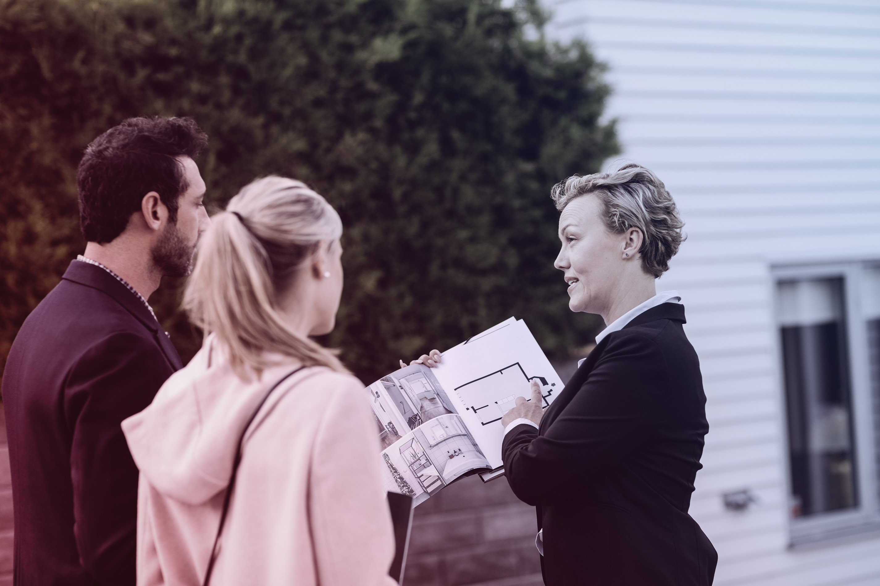 Vrouw laat tekeningen zien aan andere vrouw en man