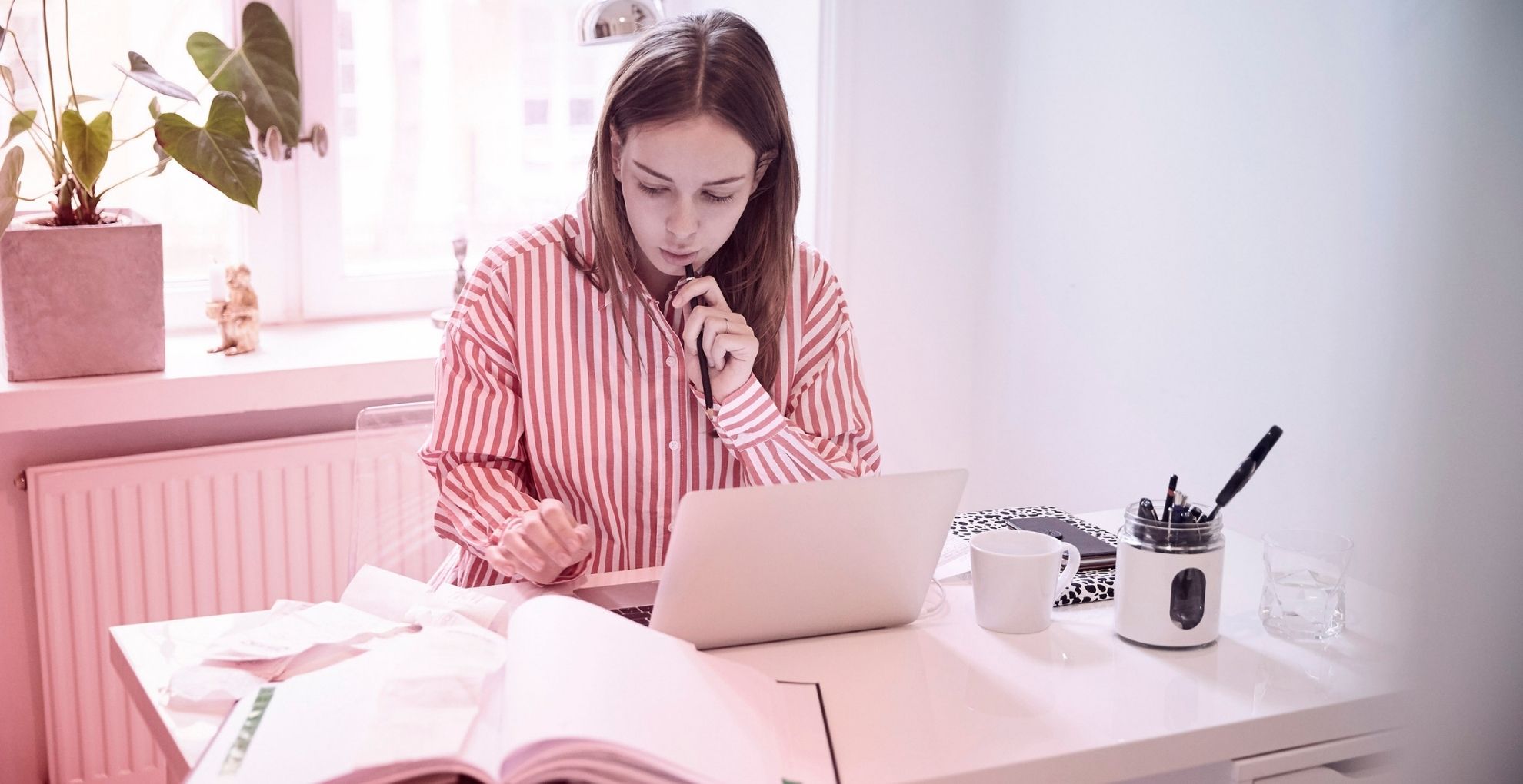 Vrouw nadenkend aan bureau met boeken en papieren