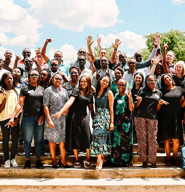 A large group of people all standing bunched up for a group photo