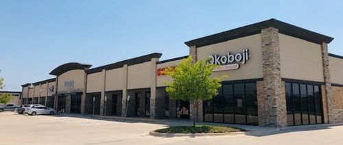 High-end retail center in Edmond, North Oklahoma City, corner view showcasing attractive brick buildings and premium retail storefronts.
