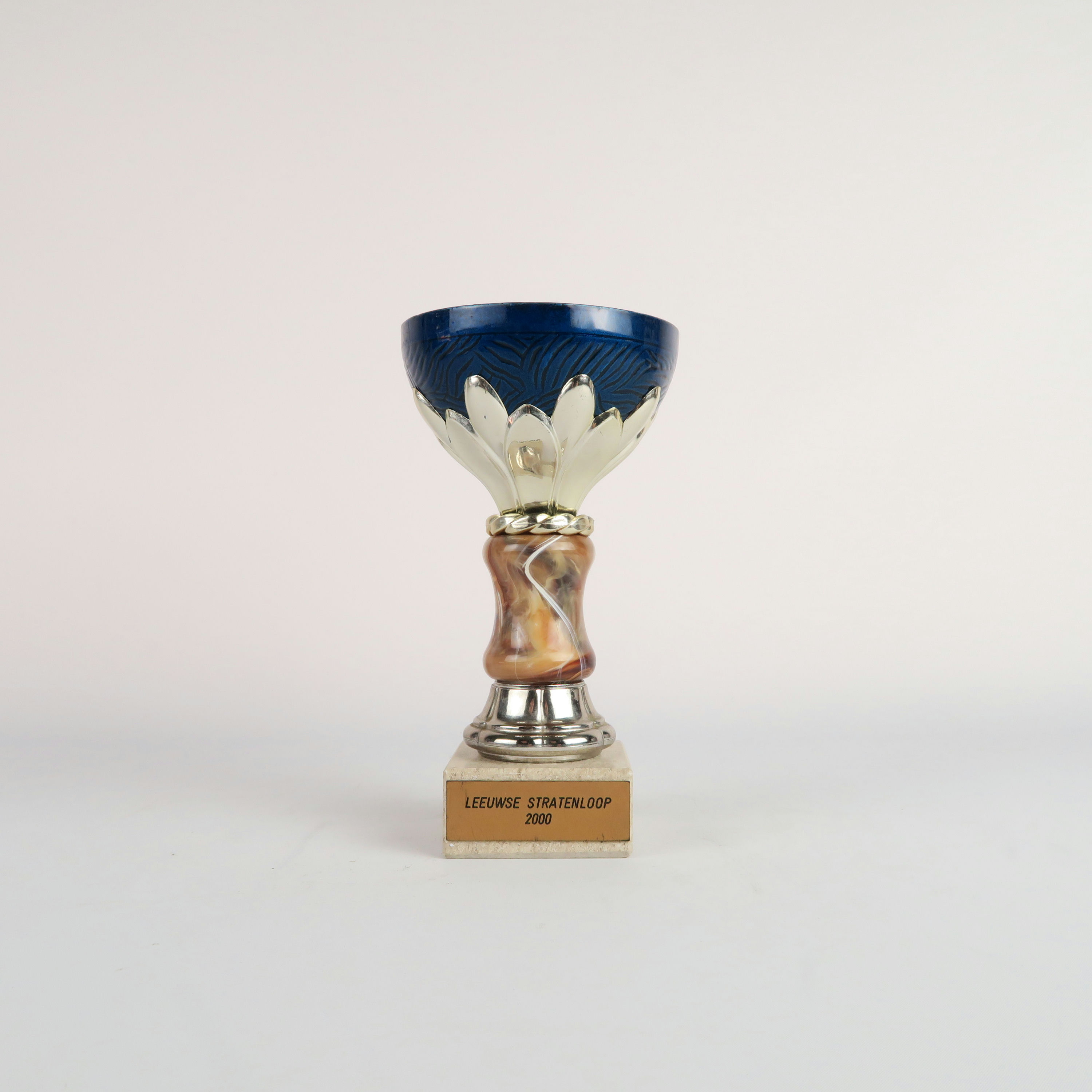 coupe bleue et argentée avec son socle en pierre