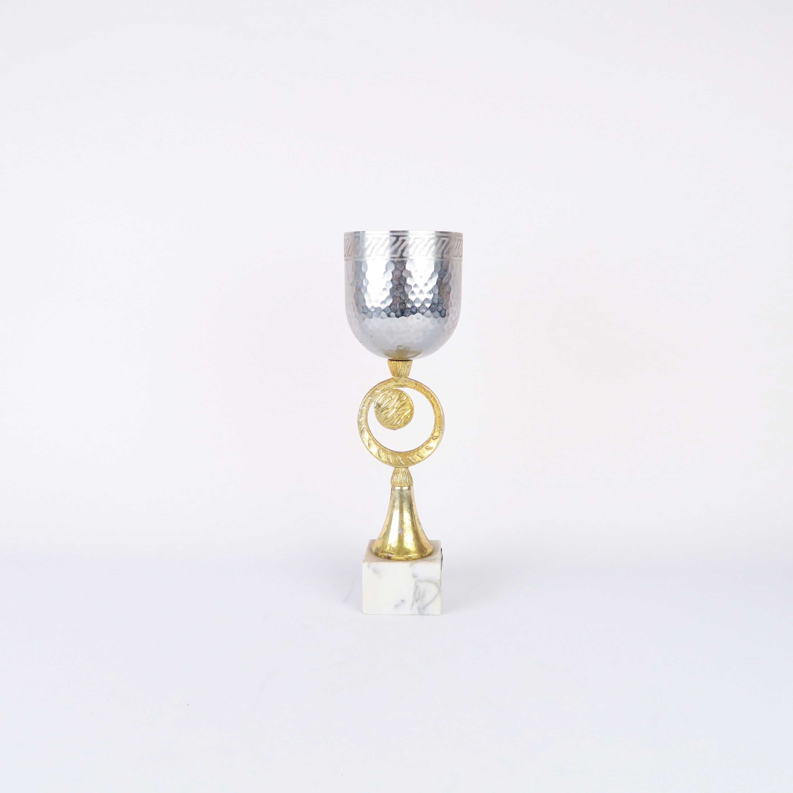 coupe argentée avec pied doré et socle en pierre blanche