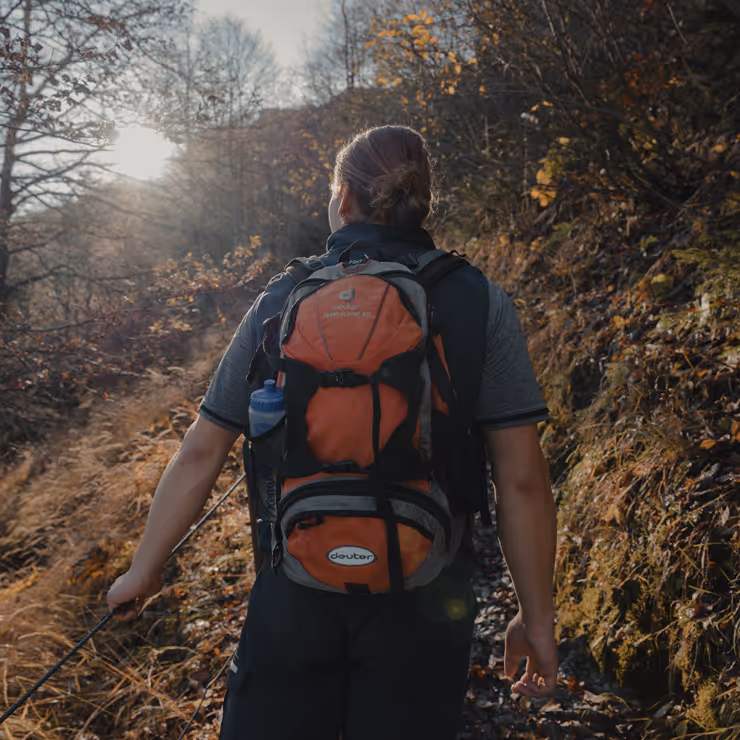 Wanderer auf dem Weg zur Bachschmied Kaser Alm durch einen herbstlichen Wald