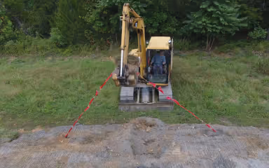 Image from a test dig of Signaltape® Underground Warning Tape being pulled out of the ground by an excavator to demonstrate anti-shearing property.