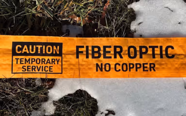 Image of Channeltape™ Utility Identification Sleeve being used to protect a temporary fiber drop laying on snow covered ground.