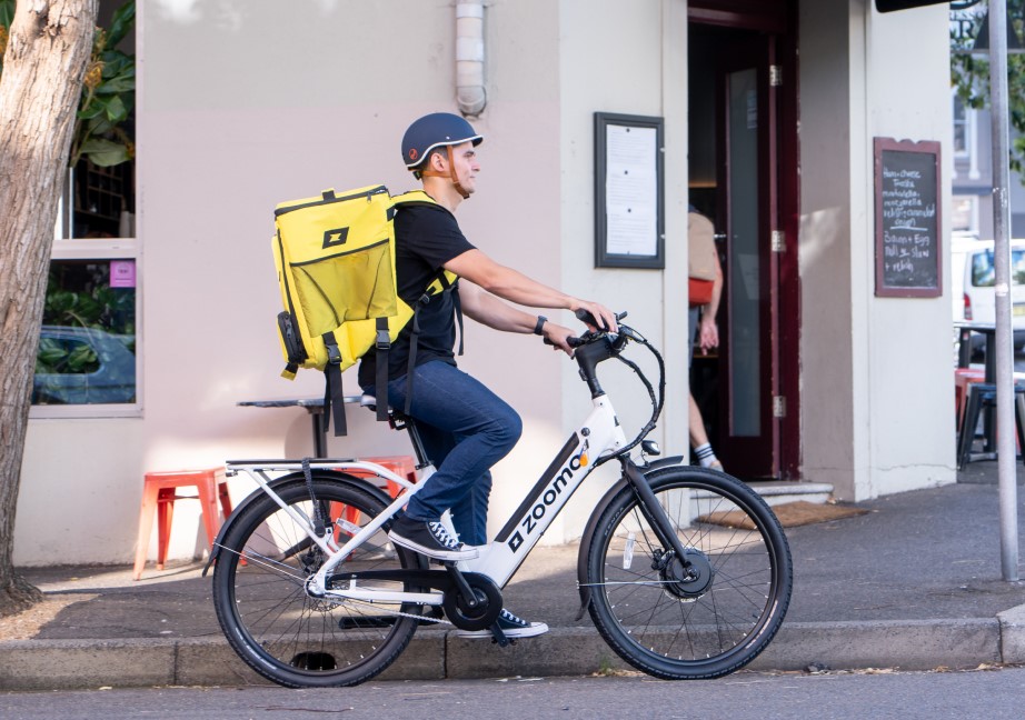 Delivery rider on a Zoomo e-bike in a Paris street