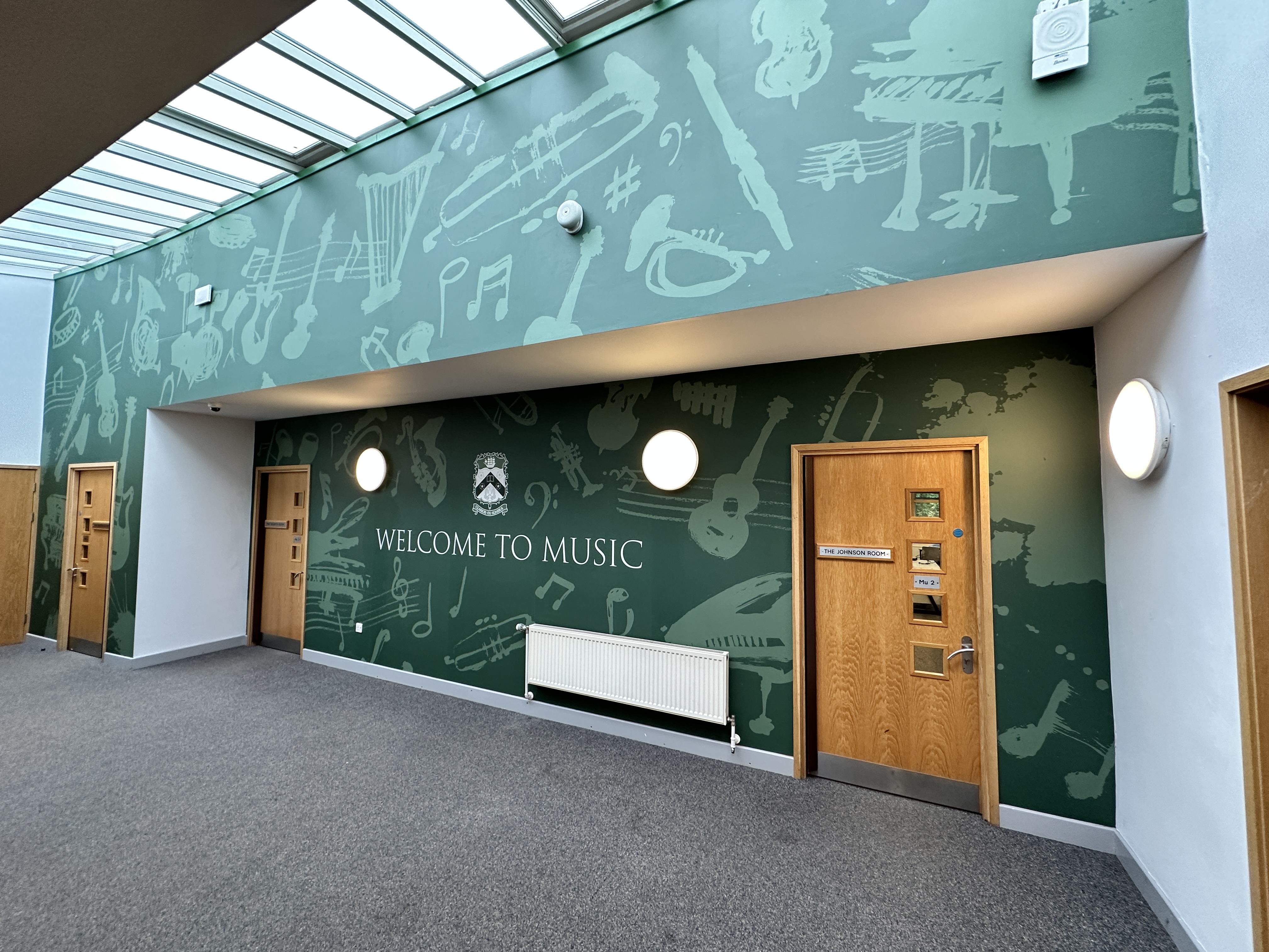 This elegant, music-themed wall art brings a classic and regal atmosphere to Silcoates School. The design features subtle graffiti-style illustrations of musical instruments, capturing the fun of learning an instrument with a sophisticated touch, blending artistic design with musical education.