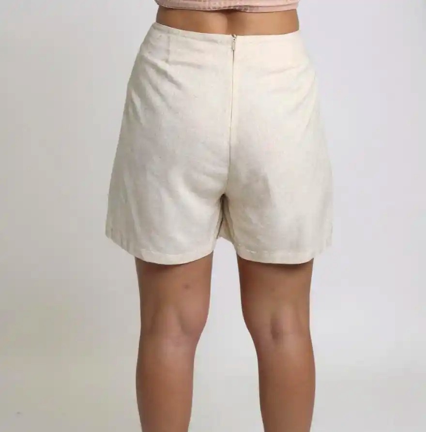 Short en lino lavado con cintura alta, bolsillos laterales invisibles y pliegues marcados que aportan volumen controlado. Tejido ligero y transpirable ideal para un estilo relajado y elegante en días cálidos.