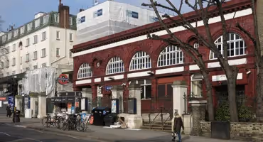 Women walking past the front on Belsize Park tube station.