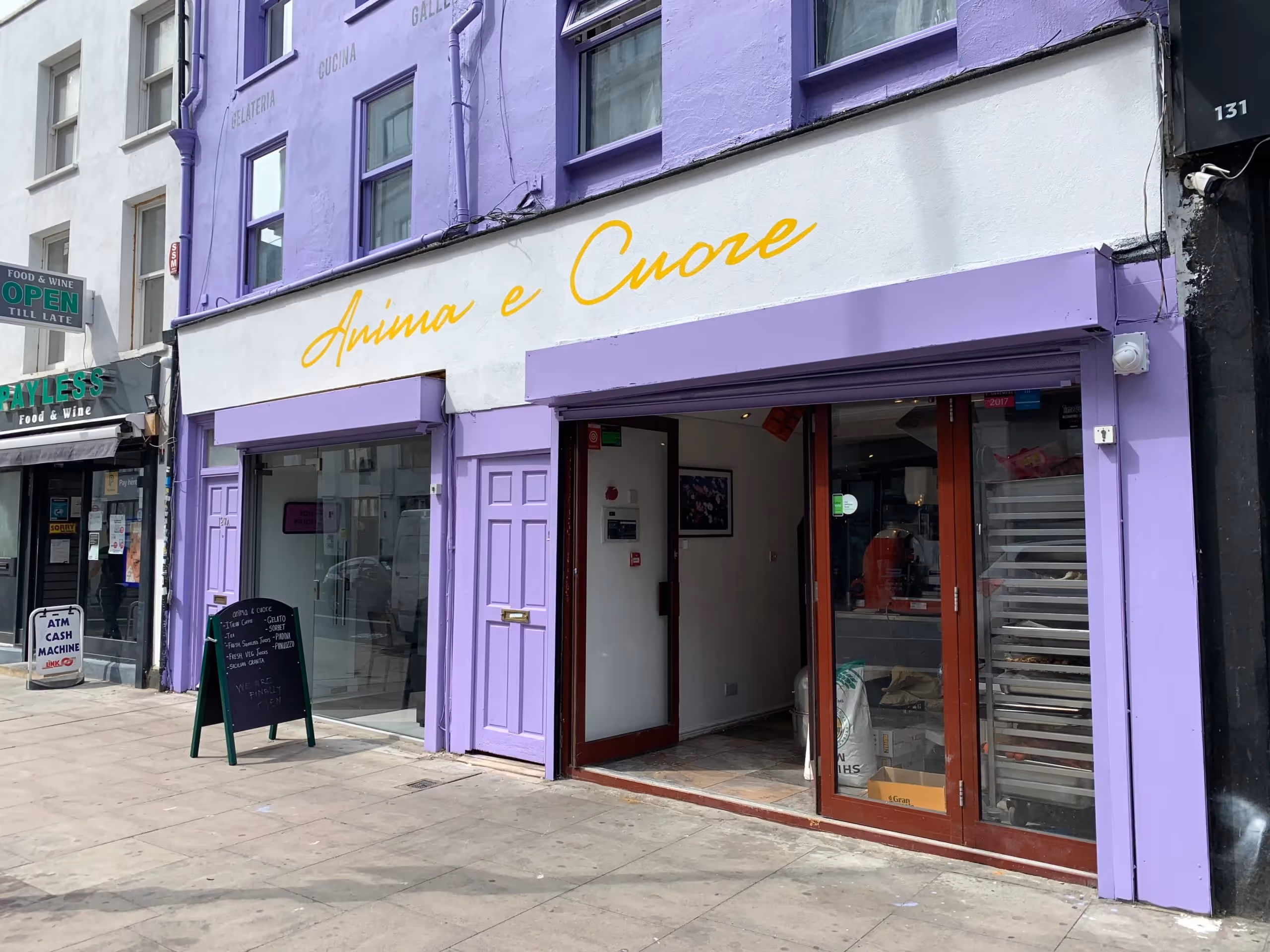A busy waitress carrying a dish in a very busy Anima E Cuore in Kentish Town.