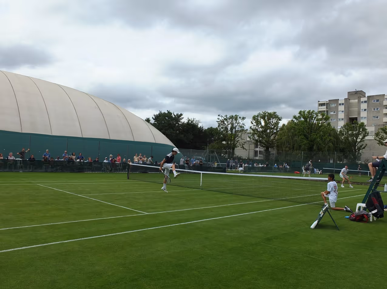 Tennis players playing on a grass court at Ealing Lawn Tennis Club.
