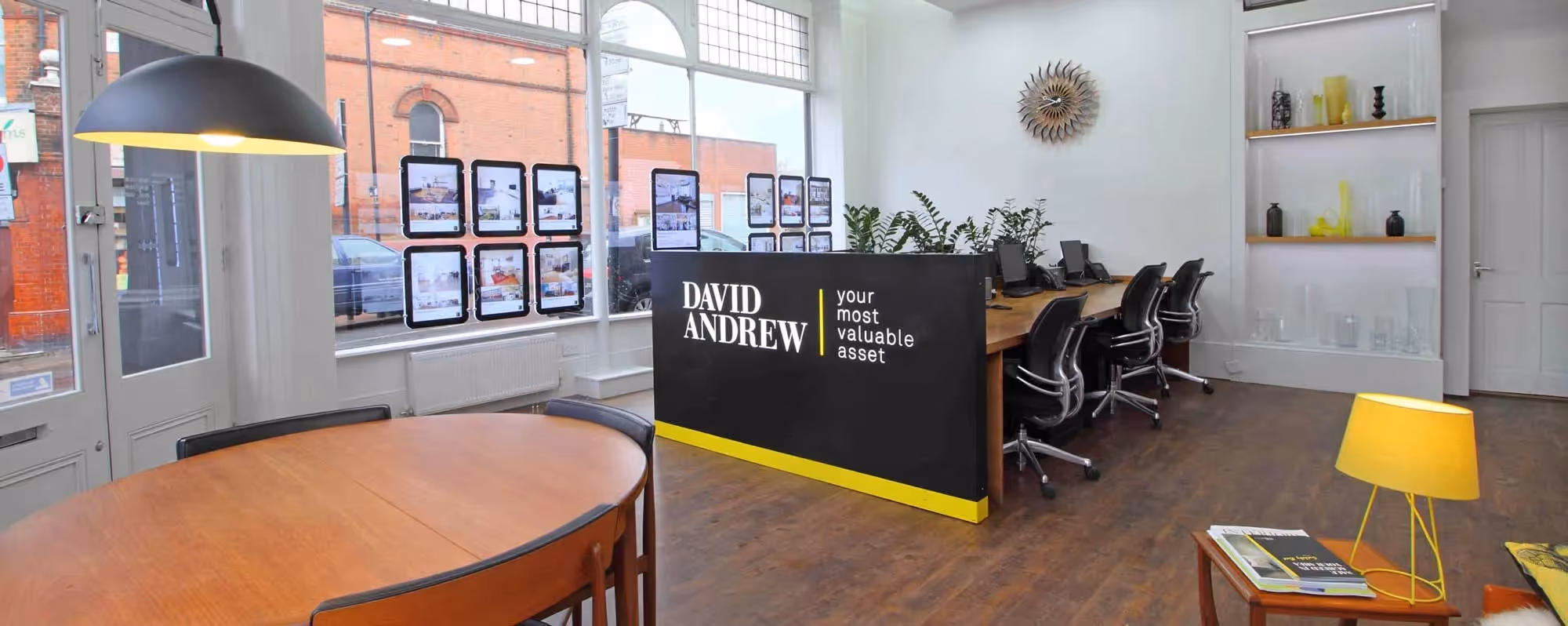 Exterior of David Andrew estate agents at night with the sign lit up.