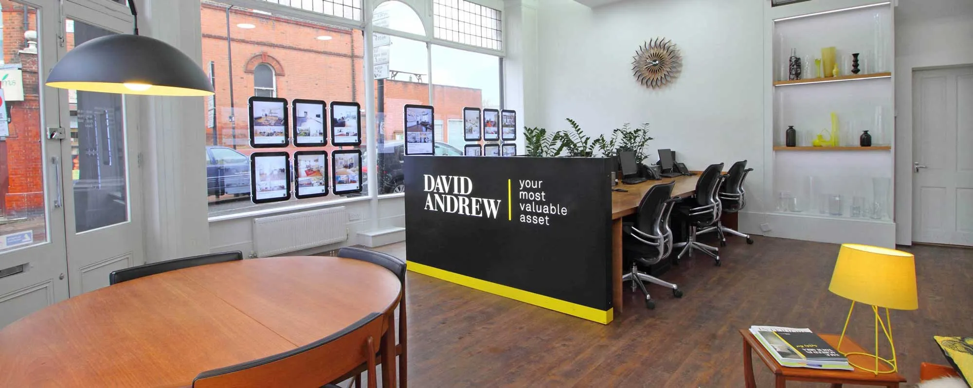 Exterior of David Andrew estate agents at night with the sign lit up.