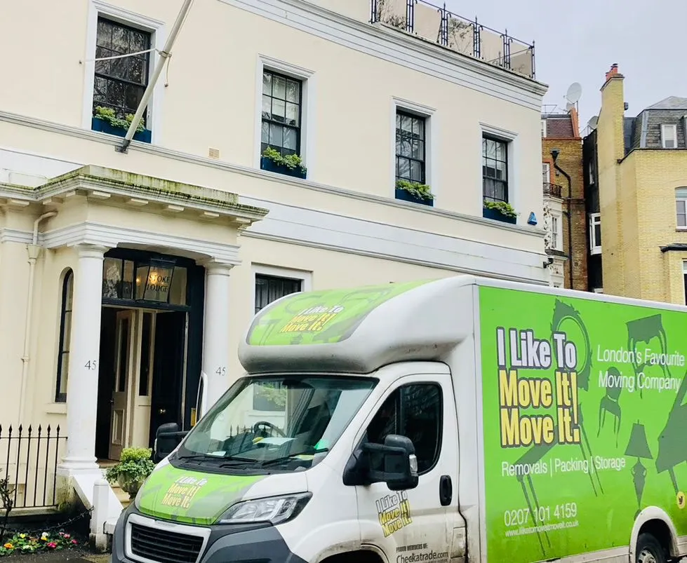 Man and Van crew loading boxes from stucco fronted white mansion house near Bayswater W2