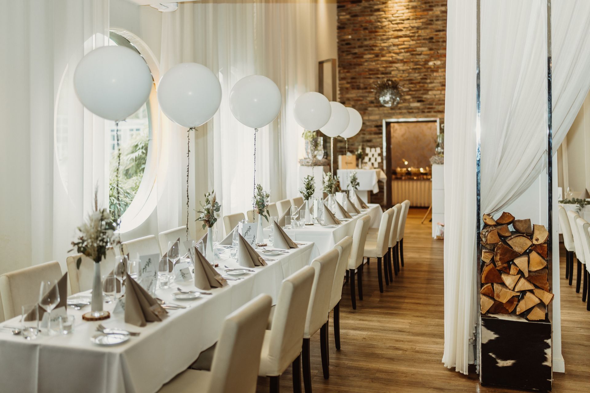 White balloons floating above palace settings at a table